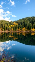 Fototapeta premium Serene autumn lake reflecting vibrant forest hues