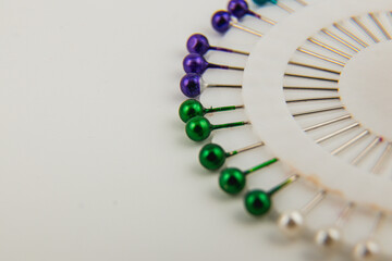 Colorful pins arranged in a circular pattern on a white surface