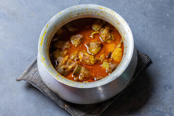 Close-up of flavorful, aromatic Bangladeshi Beef Curry in a silver pot. Traditional, slow-cooked, spicy meat dish popular in South Asia. Authentic home-style food.