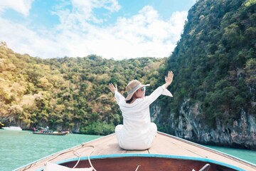 Happy Woman tourist in private longtail boat trip to koh Hong lagoon island at Krabi, Thailand....