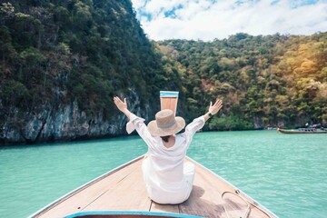 Happy Woman tourist in private longtail boat trip to koh Hong lagoon island at Krabi, Thailand....