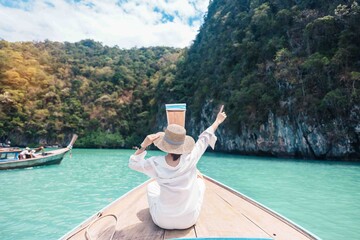 Happy Woman tourist in private longtail boat trip to koh Hong lagoon island at Krabi, Thailand....