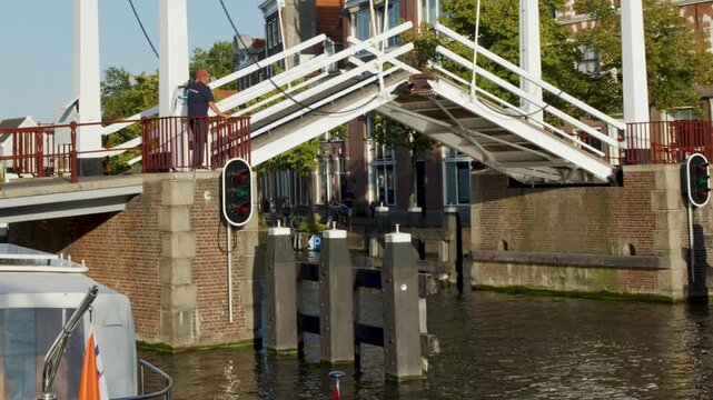 Motorboat Passing Under Raised Drawbridge in Haarlem Canal