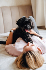 Woman relax on couch with puppy, happy and content at home with pet