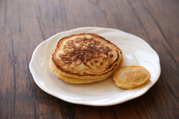 白い皿に乗ったパンケーキと小さいパンケーキ