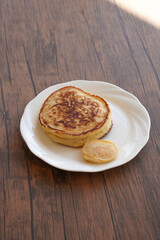 白い皿に乗ったパンケーキと小さいパンケーキ