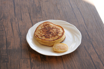 白い皿に乗ったパンケーキと小さいパンケーキ