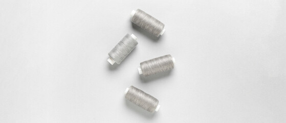 Fototapeta premium Spools of threads on light background, top view