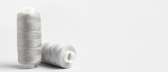Spools of threads on light background with space for text