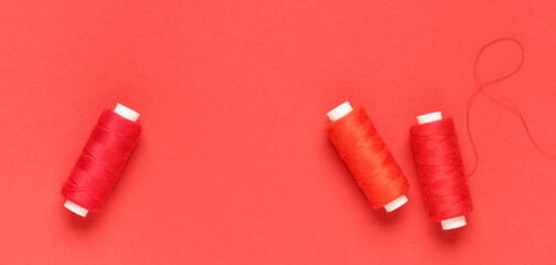 Spools of threads on red background, top view