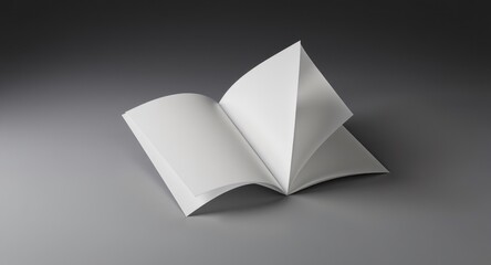 Open, blank white book with pages fanned on a gray surface, subtle lighting