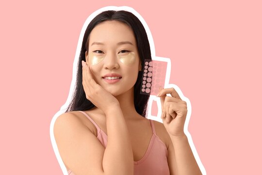 Young Asian woman with under-eye and pimple patches on pink background