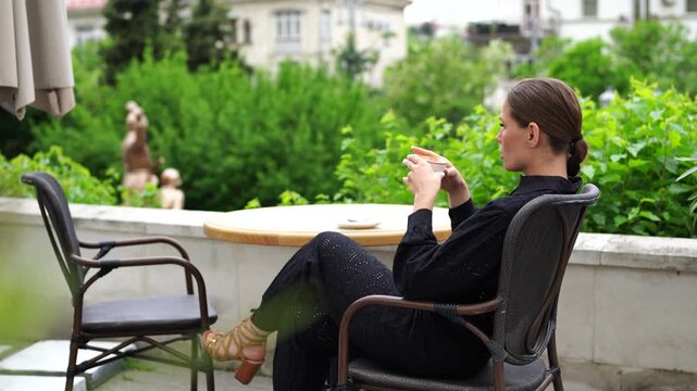 Coffee Woman Relaxation: Woman drinks coffee on patio in daytime, relaxing and enjoying the view.