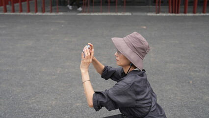 スマホで撮影する女性の横顔