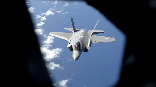 F-35 fighter jet soars through blue skies framed by a cockpit view in flight