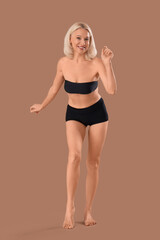 Naklejka premium Beautiful happy mature woman on beige background