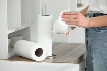 Woman wiping bowl with paper napkin at kitchen counter