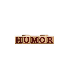 Wooden blocks spell "HUMOR" against a stark black background, clean and simple