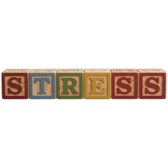 Wooden blocks spelling "STRESS" against a black background, used to visually represent the word