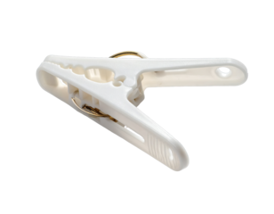 White plastic clothespin with metal spring on black backdrop