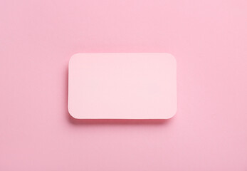 Blank invitation card on pink background, closeup