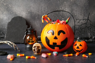 Baskets with tasty treats and decorations for Halloween on dark background