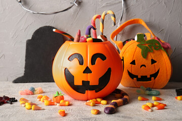 Basket with tasty candies and decorations for Halloween on grunge background