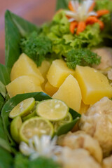 Boiled potato chunks (kentang rebus) styled on a banana leaf with lime slices and parsley — suitable for cookbooks, editorial culinary, menus and packaging