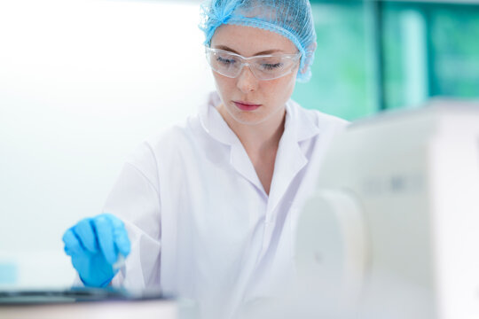 A geneticist prepares a crucial DNA sample for genomic sequencing, using sterile tweezers to prevent cross contamination while adhering to strict laboratory protocols for accuracy.