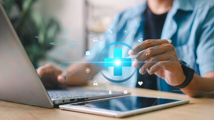Medical technology concept. Close-up of person using laptop and tablet with digital healthcare icons overlay. Concept for telemedicine, health data, and digital innovation.