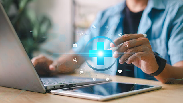 Medical technology concept. Close-up of person using laptop and tablet with digital healthcare icons overlay. Concept for telemedicine, health data, and digital innovation. - Powered by Adobe
