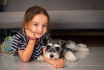 Portrait of a child with a dog on the floor