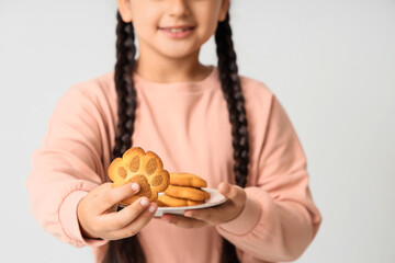 Little girl with paw shaped cookies on white background, closeup