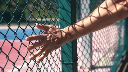 Hand Touching Metal Fence at Urban Basketball Court. Street Sport and City Vibes - Powered by Adobe