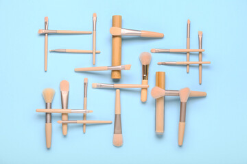 Composition with different makeup brushes, mascara and concealer on blue background