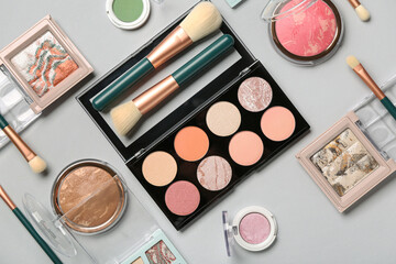 Composition with cosmetic products and different makeup brushes on white background, closeup