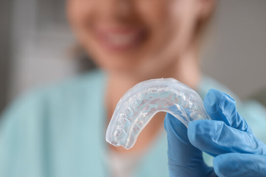 Female dentist with occlusal splint in clinic, closeup