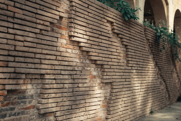 Unique Textured Brick Wall Design with Sunlight Shadows. Architectural Facade Pattern, Old Masonry Background. Rustic Building Exterior Detail.