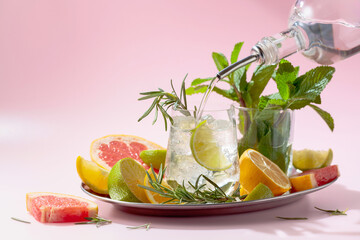 Cocktail with ice, citrus, rosemary and mint.