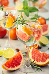 Refreshing summer cocktails with citrus on a white marble table.