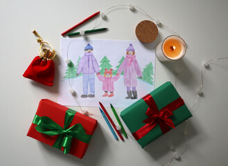 Festive winter family drawing with gifts, candle, and colored pencils on a white background. Winter activities. Perfect for Christmas and New Year holiday illustrations, decorations creative projects.