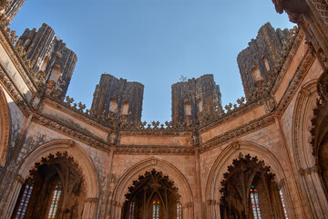 Architectural detail of the unfinished chapel in Batalha with Gothic tracery and pinnacles on a...