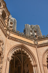 Obraz premium Architectural detail of the unfinished chapel in Batalha with Gothic tracery and pinnacles on a clear, monumental day