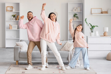 Obraz premium Happy parents with their little daughter dancing at home