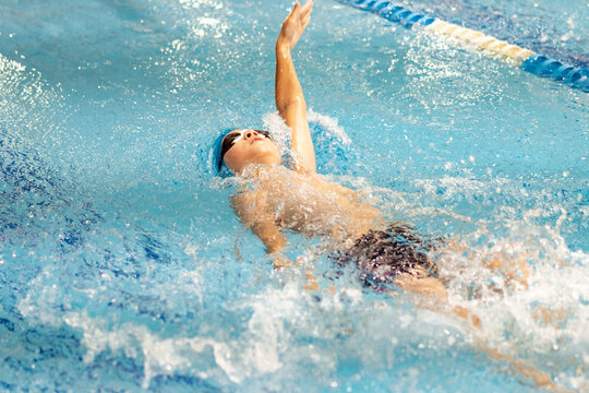 boy swimming backstroke in a pool