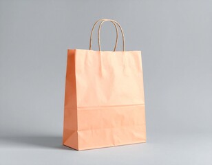 Simple peach paper shopping bag with handles on a neutral background