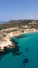 Fototapeta premium Turquoise bay with rocky cliffs and green hillside