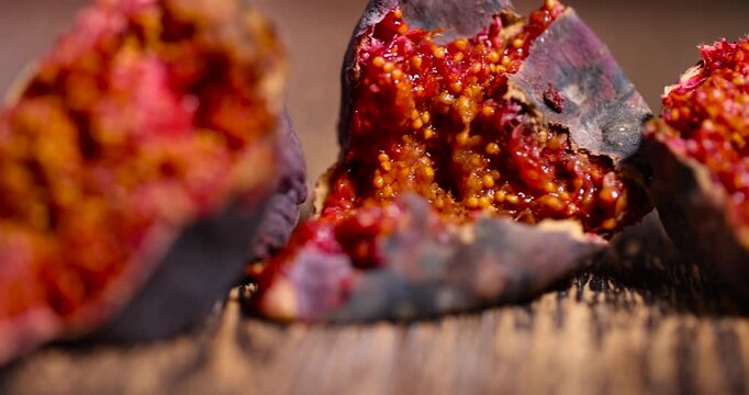 moldy overripe and spoiled figs with red flesh and seeds on a table, moldy spoiled figs with lots of grains