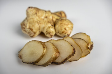 Jerusalem artichoke with slices pieces isolated on a white background.