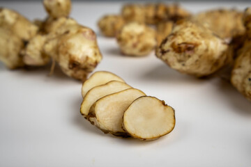 Jerusalem artichoke with slices pieces isolated on a white background.